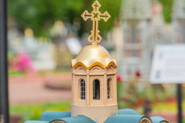 Görüntüde Bizans ve Doğu Ortodoks etkisine sahip minyatür bir kilise modeli, kubbe şekli, altın haç, tabandaki sütunlar ve küçük galibiyet Kyiv, Ukrayna 06-11-2024 gibi ayrıntılar yer alıyor.
