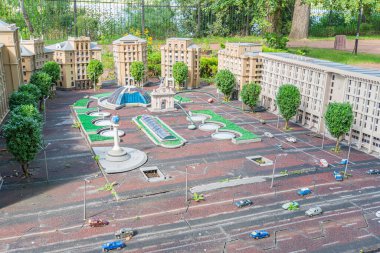 Minyatür bir şehir meydanı modelinde konut ve ticari yapıların bir karışımı sergilenirken, içinde bir çeşme bulunan merkez plazada yayalar ve veh Kyiv, Ukrayna 06-11-2024