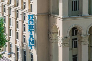 Resim klasik elementler sütunları ve modern tabela POST ile bej taştan bir bina içeriyor. Simetrik pencereleri var, muhtemelen her iki işlevsellik için tasarlanmış bir Kyiv, Ukrayna 06-11-2024