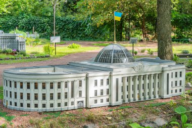Görüntü, Ukrayna Verkhovna Rada 'nın sessiz renkler ve çevresindeki yeşilliklerle klasik mimarinin ayrıntılı bir kopyasını tasvir ediyor.