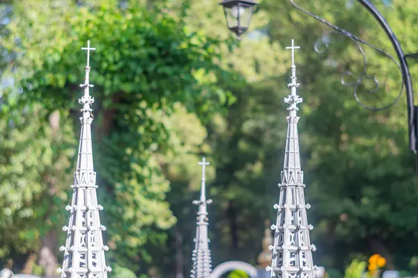 Yeşil arka planda sergilenen kule ve kuleler de dahil olmak üzere karmaşık Gotik mimari modellerin bir sıra görüntüsü, kabartma, sivri uçlu Kyiv, Ukrayna 06-11-2024