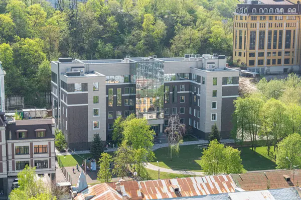 Metal kenarlar ve cam paneller gibi ön cephe tedavilerinin bir karışımını sergileyen balkonları, yeşilliği ve birden fazla bloğu olan modern bir yerleşim yeri. Açık bir g Kyiv, Ukrayna 06-11-2024 içeriyor.