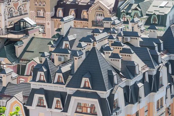 Çeşit çeşit mimari tarzlara sahip binaların bir koleksiyonu, çatılar ve yatakhane pencereleri ön planda, ön cephelerdeki pencereler ise Sid Kyiv, Ukrayna 06-11-2024