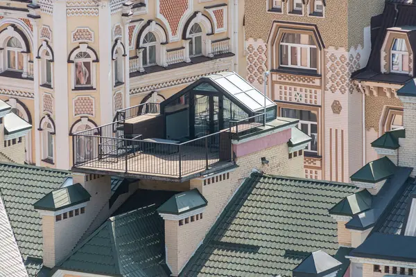 Mimari tarzların harmanlandığı tarihi çok katlı bina görüntüsü, çatıda birden fazla yamaç ve çember barındıran modern bir ekleme Kyiv, Ukrayna 06-11-2024 bölümünden görülebilir