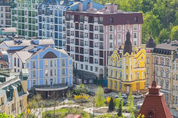 Bu resim, mimari stil ve renklerin bir karışımını sergileyen, sıkıca doldurulmuş konut binalarıyla canlı, kentsel bir manzara tasvir ediyor. Mimaride ornat Kyiv, Ukrayna 06-11-2024 yer alıyor.