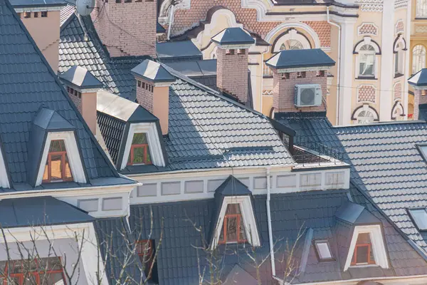 Görüntü, eski binaların dış sahaları, yurt pencereleri ve koyu renkli fayansların yer aldığı büyüleyici, geleneksel bir Avrupa yerleşim alanını gösteriyor. Düşük güneşli Kyiv, Ukrayna 06-11-2024