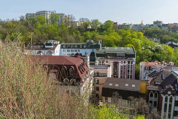 Resim, çeşitli mimari tarzlara ve dönemlere sahip tarihi bir Avrupa şehir manzarasını resmediyor, yoğun kentsel yapıda kırmızı tuğla ve taş binalar sergiliyor. Dikkat çekici özellikler i Kyiv, Ukrayna 06-11-2024