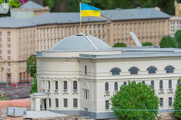 Çoklu gable, yurt pencereleri ve dekoratif unsurlara sahip bir minyatür neoklasik model. Karmaşık detaylar sergiliyor. Bayrak direğine sahip, Kyiv, Ukrayna 06-11-2024