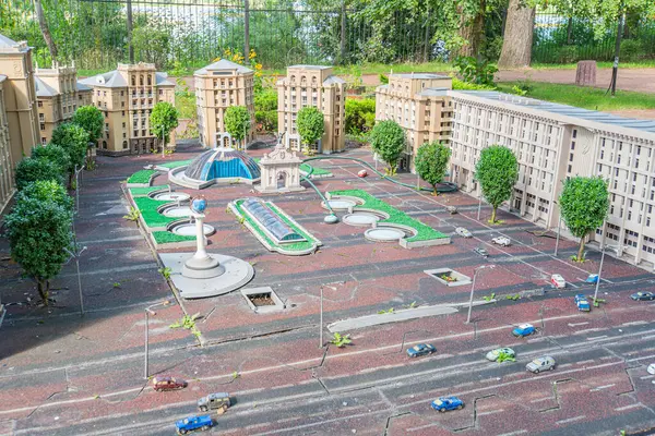 Minyatür bir şehir meydanı modelinde konut ve ticari yapıların bir karışımı sergilenirken, içinde bir çeşme bulunan merkez plazada yayalar ve veh Kyiv, Ukrayna 06-11-2024