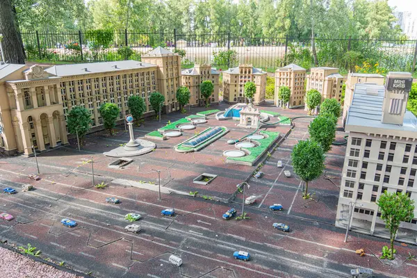 Toprak tonlarında büyük, simetrik, neoklasik bir Palladyen binanın detaylı bir minyatür modeli, muhtemelen açık kamusal alanı ve Kyiv, Ukrayna 06-11-2024 'ü çevreleyen kentsel bir çevreyi tasvir ediyor.