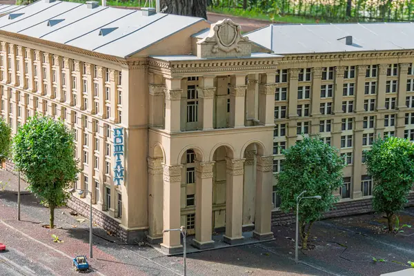 Simetrik cepheli, süslemeli ve eşit aralıklı pencereli neoklasik bir bina. Çatı pürüzsüzdür ve açık sarı bej rengi Kyiv, Ukrayna 06-11-2024