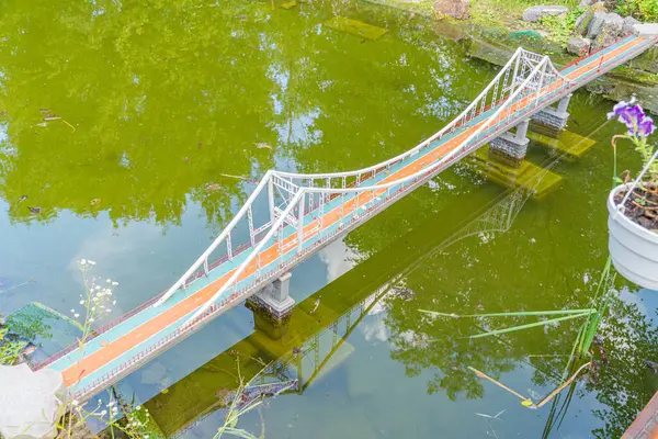 Birden fazla kemeri olan canlı, işlevsel bir yaya köprüsü yemyeşil bir zemin üzerinde bir su kütlesi oluşturarak mimari ve doğa Kyiv, Ukrayna 06-11-2024 arasındaki uyumu gösterir.