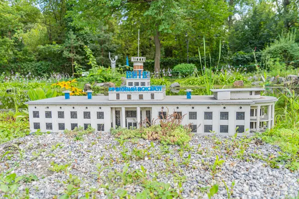 Çakıl ve bitki temelindeki geleneksel bir binanın minyatür mimari modeli, muhtemelen tarihsel veya dikkate değer, simetrik cepheli, eşit aralıklı pencereli, merkezi en Kyiv, Ukrayna 06-11-2024