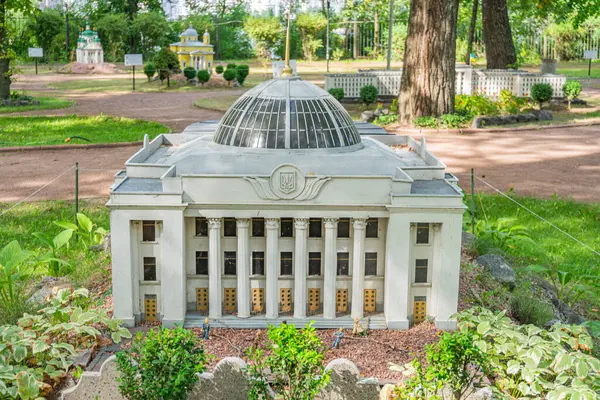 Görüntü, Ukrayna Verkhovna Rada 'nın sessiz renkler ve çevresindeki yeşilliklerle klasik mimarinin ayrıntılı bir kopyasını tasvir ediyor.