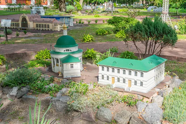 Avrupa mimarisi ile bir model köy sahnesi, küçük kümeli binalar ve uzun bir kilise kulesinin yer aldığı manzara yemyeşil bir araziyi kapsıyor, Ukrayna, 06-11-2024