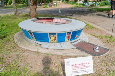 Parktaki amfi tiyatro ortamında bulunan eşsiz, mavi panelli silindir bir heykel. Silindir görsel bir anlatım içeriyor ve daha büyük bir Kyiv, Ukrayna 06-11-2024 'ün parçası olabilir.