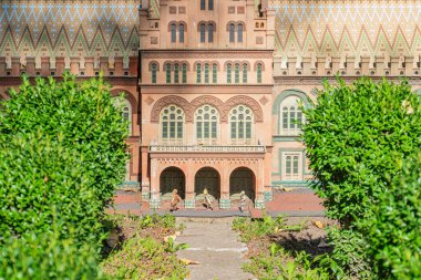 Detaylı ve karmaşık pencere tasarımları olan kırmızı tuğla bir bina Gotik Uyanış, Tudor ve Flaman mimari etkilerinin bir karışımını sergiliyor. The w Kyiv, Ukrayna 06-11-2024
