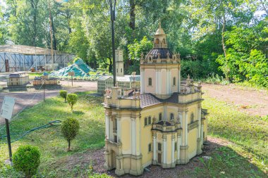 Bahçedeki minyatür bir şato. Karmaşık kuleler, süslü kuleler, taş benzeri dokular ve ağaçlarla çevrili bir çatı ile detaylandırılmış. Ukrayna, 06-11-2024