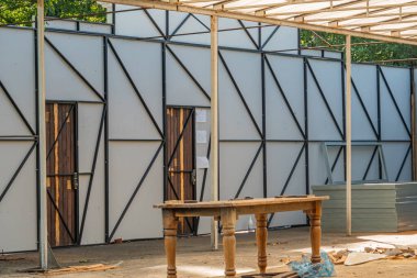 Montaj altında modüler bir binaya sahip aktif bir inşaat alanı görüntüsü Yapı çelik çiviler tarafından desteklenen prefabrik duvar panelleri serpilmiş enkazlar ve t Kyiv, Ukrayna 06-11-2024