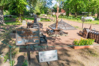 Görüntü, eski mekanik alet ve makinelerin sergilendiği tarihi bir park veya miras alanı tasvir ediyor. Sahnede büyük bir metal endüstriyel makine, ahşap bir yapı yer alıyor. Kyiv, Ukrayna 06-11-2024