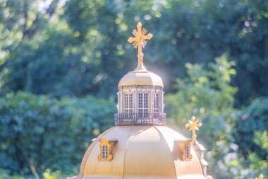 Altın kubbeli dini bir binanın büyüleyici bir görüntüsü, süslü haçlar ve yemyeşil alanlara karşı hazırlanmış bir gözlem güvertesi, dinsel s Kyiv, Ukrayna 06-11-2024 'ün birleşimini temsil ediyor.