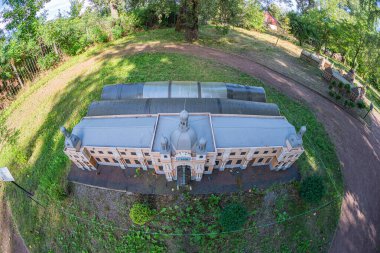 Görüntü simetrik cepheli bir neoklasik bina, çoklu sütunlar, sütunlar, kemerli pencereler ve modern metal bir çatı gösteriyor. Ukrayna, Kyiv, Ukrayna 06-11-2024 'te tepedeki ağaçlarla çevrili.