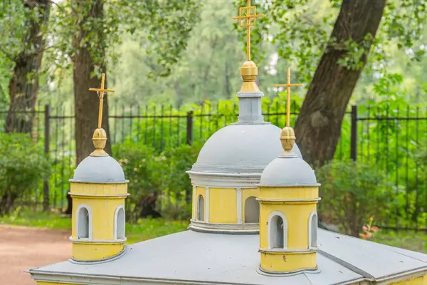 Sarı tabanlı ve turkuaz kubbeli Doğu Ortodoks mimarisi sergilenen minyatür bir Bizans kilise modeli, muhtemelen bir park veya kamu alanı Kyiv, Ukrayna 06-11-2024