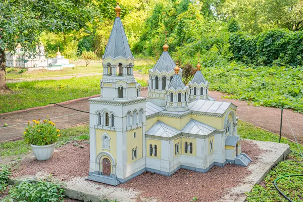 Küçük bir bahçeyle çevrili minyatür bir Gotik kilise modeli. Yapı, mimari ayrıntıları gözler önüne seriyor. Tarzlar Kyiv, Ukrayna 06-11-2024 'ü işaret ediyor.