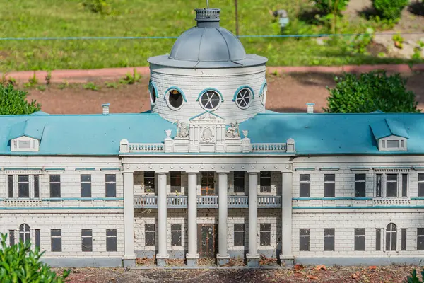 Gri ve mavi renkte soluk renk paleti olan büyük, simetrik bir taş ya da duvar taşı çok sayıda pencere, karmaşık detaylar, merkezi bir giriş, düz bir çatı katı Kyiv, Ukrayna 06-11-2024