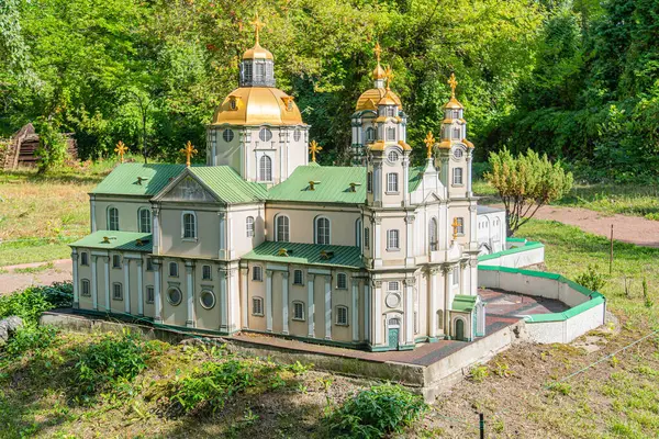 Üç katmanlı minyatür bir Ukrayna Ortodoks kilise modeli, birden fazla kubbe ve haçlar, yemyeşil bir zemin üzerine kurulmuş, parlak çatılı soluk renk paleti sergiliyor Kyiv, Ukrayna 06-11-2024