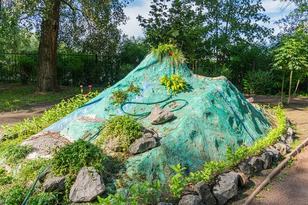 Doğal formlardan esinlenilmiş, bitki ve çiçeklerle süslenmiş merkezi bir kaya tepeciğinden oluşan eşsiz, organik bir yapı tasarım, doğal ve minimalist Kyiv, Ukrayna 06-11-2024 'ün bir birleşimini sergiliyor.