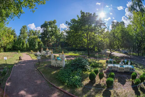 Minyatür ahşap yapıları olan büyüleyici, kaprisli bir bahçe, peri masalı bir atmosferi çağrıştırıyor. Manikürlü bahçede gölgeler bırakan ağaçlar var. Güneşli bir günü işaret ediyor.