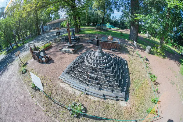 Teras ya da bahçe alanı basit mimari, bank, kuş heykeli, kırmızımsı asfalt, küçük ağaç, gündüz manzarası, dinlenmek için huzurlu açık alan ya da Kyiv, Ukrayna 06-11-2024