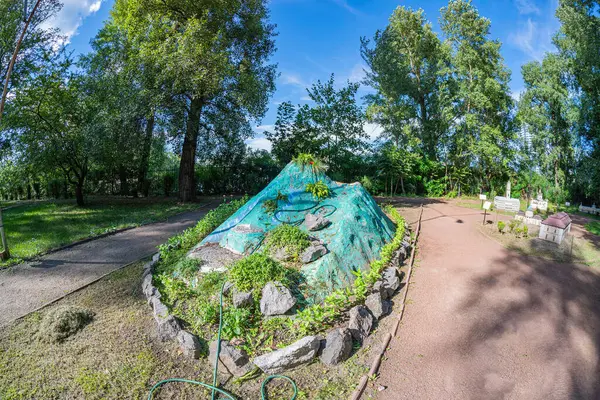 Geleneksel ve modern mimarinin bir birleşimi olarak, resim taşla kaplanmış, yemyeşil bir bahçeyle çevrili dairesel bir tümsek sergiliyor. Merkezi özellik B Kyiv, Ukrayna 06-11-2024 gibi görünüyor.