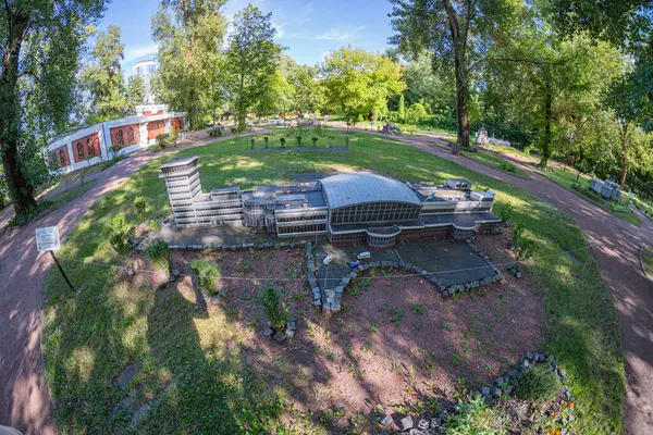 Çürüyen tarihi bir harabe, muhtemelen bir amfitiyatro ya da kuru bir çeşme, sakin bir bahçede yemyeşil sularla kaplıdır. Mimari yapı Kyiv, Ukrayna 06-11-2024 ile uyumlu bir şekilde harmanlanır.