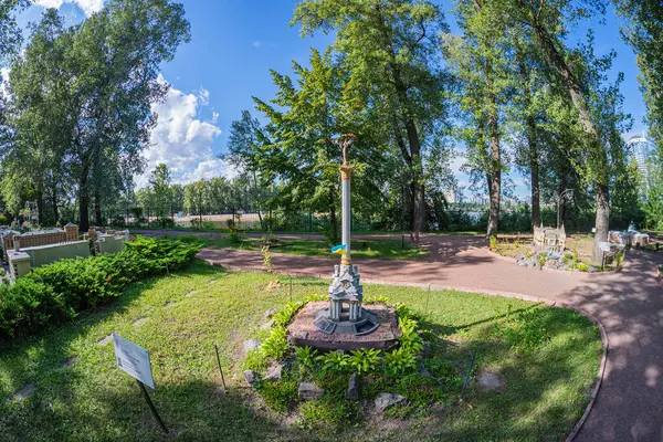 Huzurlu park sahneleri mimari ve doğanın uyumlu bir karışımını sergiliyor. Merkezi çardak, bakımlı bahçe, karmaşık yollar, ağaçlar, banklar, sokak lambaları, berrak mavi gökyüzü, Kyiv, Ukrayna 06-11-2024