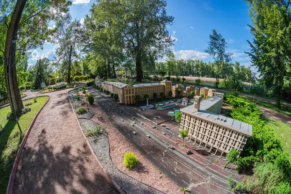 Görüntü, düz çatılar ve geometrik şekillerle karakterize edilmiş modern bir kompleksi gösteriyor. Tarafsız tonlu yapılar ağaçlar ve yeşilliklerle çevrili, Kyiv, Ukrayna 06-11-2024