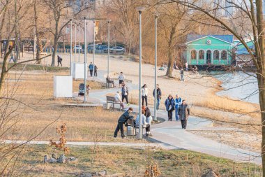 Kyiv, Ukrayna, 03-29-2025 plakalı sahil yolu, sahil yürüyüşleri, banklar ve yaya yollarının yer aldığı sakin bir su kütlesi ve etkinlikler için uygun bir sahnedir.