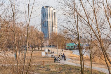 Çevresindeki Kyiv, Ukrayna, 03-29-2025 gökdeleniyle tezat oluşturan hareketli bir şehir parkı manzarası.