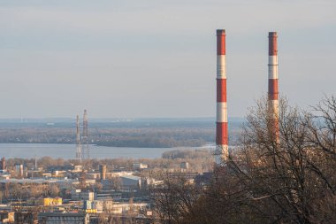 Endüstriyel bacalar, sergilenen binalar, su yolları ve güç altyapısı ile bir kentsel şehrin havadan çekilmiş görüntüleri Kyiv, Ukrayna, 03-29-2025