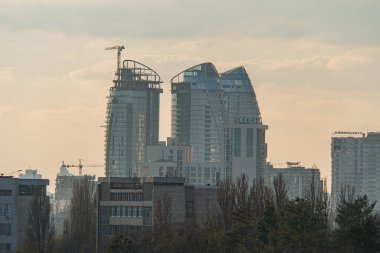 Gündoğumunda ya da batımında modern bir şehrin hava görüntüsü, gösterişli gökdelenler ve şehir karmaşası Kyiv, Ukrayna, 03-29-2025