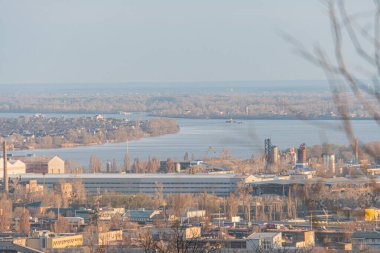 Binalar, yollar, nehir ve doğa ile nefes kesici bir şehir manzarası. Görüntü ticari ve yerleşim alanları, dinamik akış, Kyiv, Ukrayna, 03-29-2025