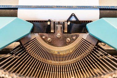 Klasik QWERTY düzen tuşları, dijital çağda tarihi ve insan yaratıcılığını sembolize eden metal çerçeve patinasıyla tezat oluşturur.,