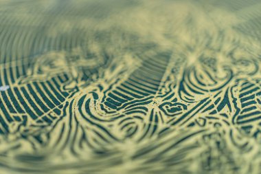 Yüksek kaliteli dokuma kumaş üzerindeki karmaşık altın desenlerinin yakın plan görüntüsü, giysi veya dekor gibi lüks eşyalarda kullanılmasını öneriyor