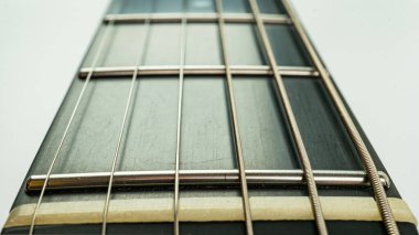 Akustik bir fretboard 'un yakın plan görüntüsü, açık bir şekilde işaretlenmiş perdeler, sıcak renkler ve pazarlama materyalleri için uygun sessiz, zarif bir atmosfer.