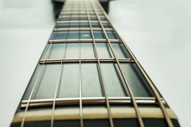 Enstrümanın güzelliğini ve duygusal yankısını vurgulayan, serin mavi arkaplana karşı bir gitar fretboard 'unun yakın çekim görüntüsü tellerin ve fretboard' un karmaşık ayrıntıları çok önemlidir.