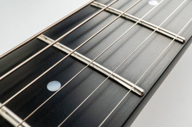 Görüntü, iyi yapılmış fretboard ve perdelere odaklanarak, karmaşık gitar işçiliğini ön plana çıkarıyor ve hassas mühendislik ve kaliteli materyalleri gösteriyor