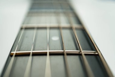 Bulanık bir arkaplanda titreşimli gitar tellerinin yakın plan görüntüsü, gerilimlerini ve metalik parıltılarını sergiliyor. Müzik ekipmanları pazarlaması veya müzik yeteneği gösterisi için kullanışlı.