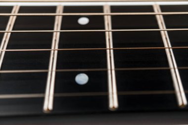 En üstteki dört tele ve perdelere odaklanan koyu renk fretboard gitarın yakın plan görüntüsü ahşap ve metal dokular, alan etkisi ve pazarda kullanılabilir.