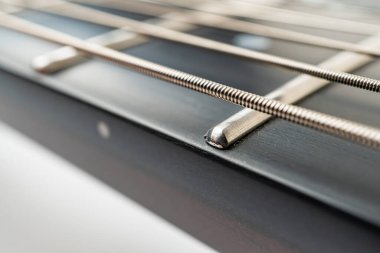 Üstten aşağı bir görüntü, sanatını ve tasarımını sergileyen bir akustik gitarı ön plana çıkarıyor. Gergin tellerle dizilmiş köprü, merkezde duruyor, doğal malzemelerden ve hintlerden gelen sıcaklığı somutlaştırıyor.